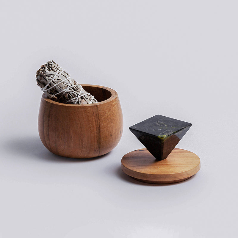 Solid black onyx round jewel box showcasing its sleek matte finish and heavy mineral materiality on a white background.