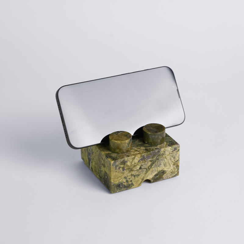 Serpentine green brick puzzle phone stand holder displaying its natural mineral veins on a white background.