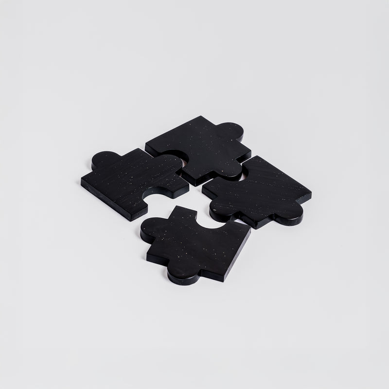 Set of 4 black onyx gemstone puzzle coasters highlighting their sleek matte finish on a white background.