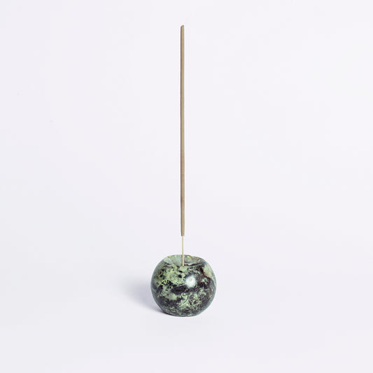 Serpentine green gemstone sphere incense holder showcasing its natural Andean stone texture on a white background.