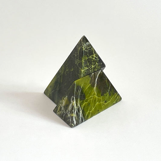 Serpentine green pyramid puzzle sculpture showcasing deep natural veins on a white background.