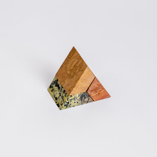 Frontal view showcasing the distinct individual blocks of the green, orange, and cream triangle puzzle candelabra, highlighting its architectural silhouette.