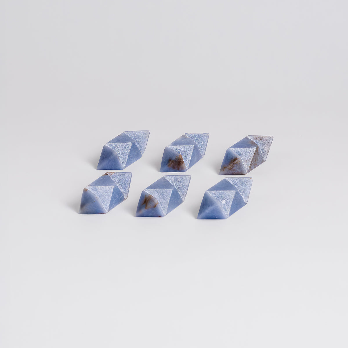 Interlocking pieces of the handcrafted angelite stone burr puzzle on a white background.