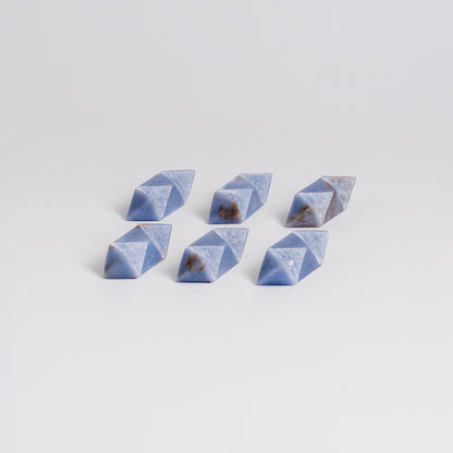 Interlocking pieces of the handcrafted angelite stone burr puzzle on a white background.
