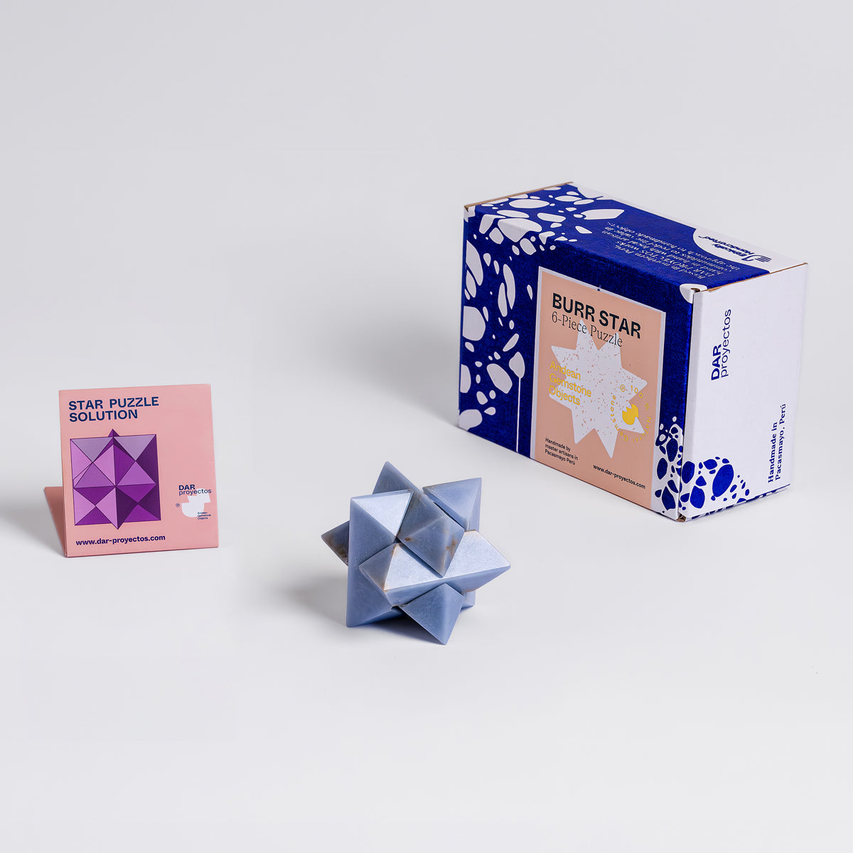 Geometric design of the blue angelite gemstone burr puzzle on a white background.