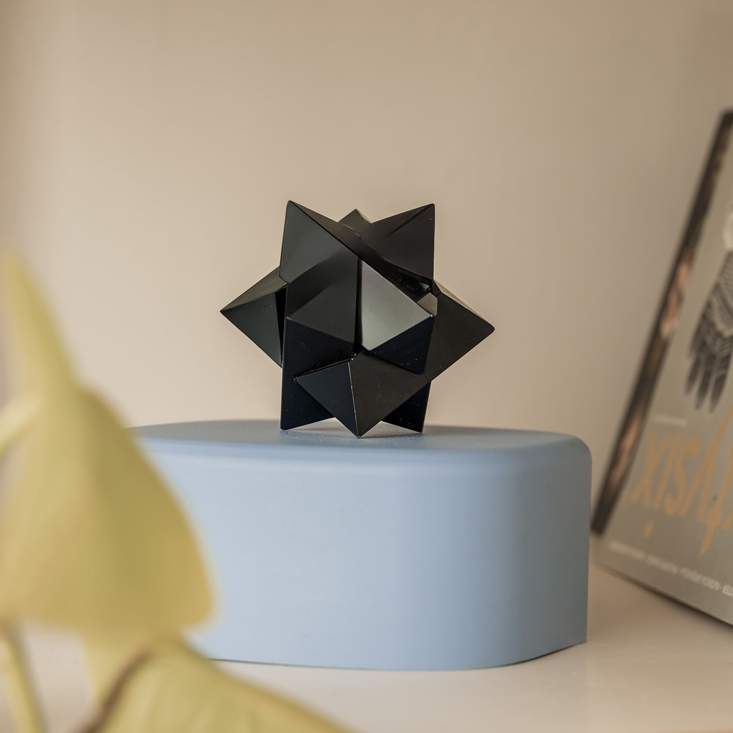 Black onyx stone burr puzzle resting on a textured surface in a quiet luxury setting.