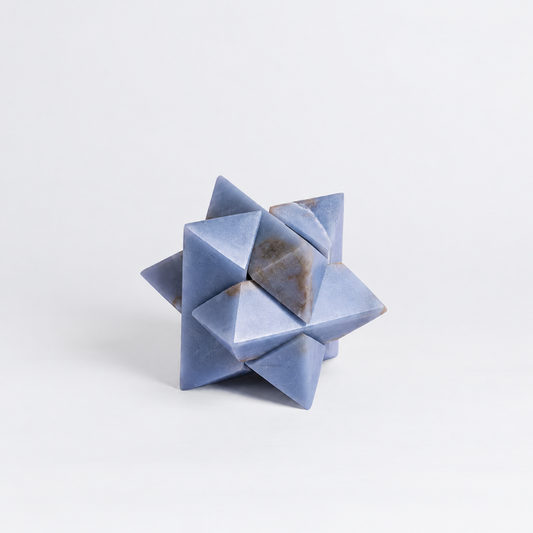 Geometric design of the blue angelite gemstone burr puzzle on a white background.