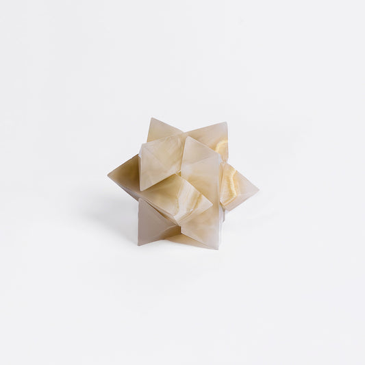 Geometric stone puzzle sculpture on a white background