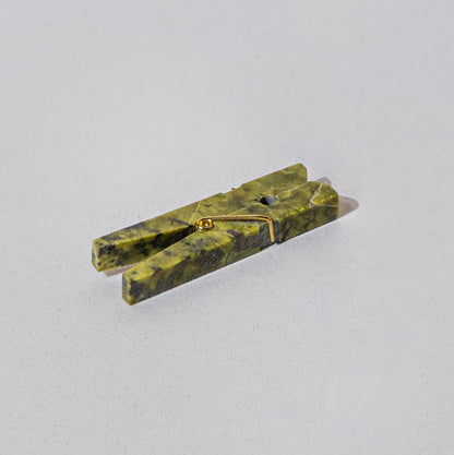 Serpentine green gemstone laundry clip highlighting natural Andean stone veins on a white background.