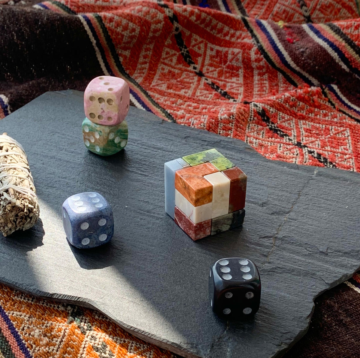 Natural gemstone puzzle adding a touch of tactile quiet luxury to a modern desk setup alongside curated books.