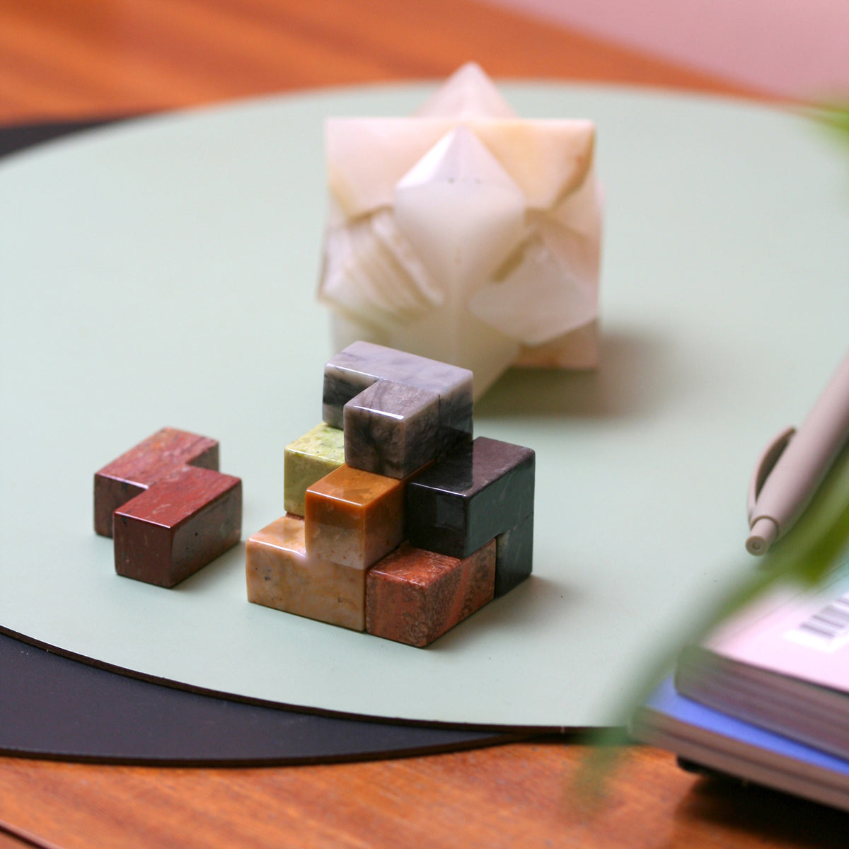 The decorative stone cube puzzle resting gracefully on a wooden coffee table, acting as an elegant slow design conversation starter.
