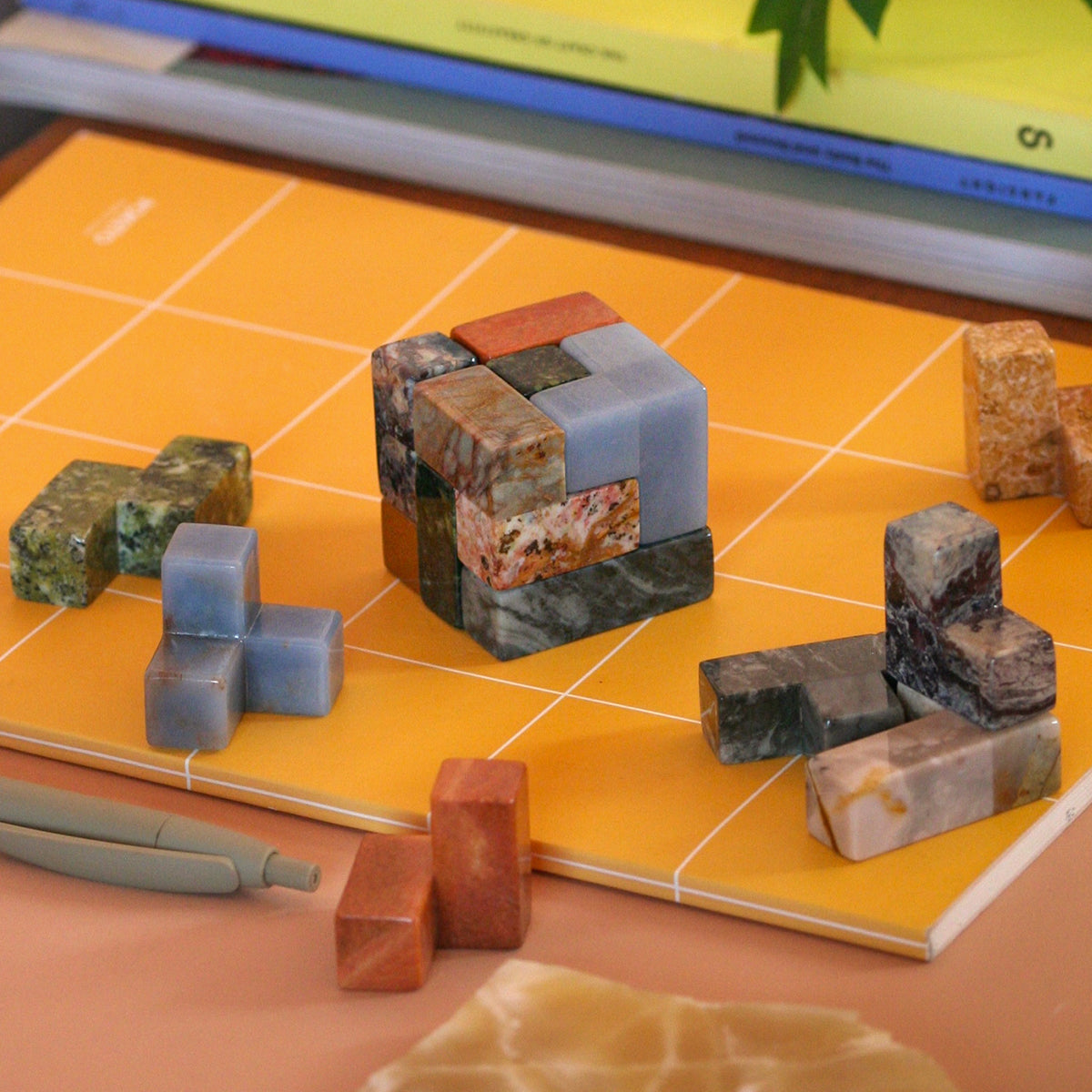 Disassembled gemstone puzzle pieces resting organically in a quiet luxury setting.