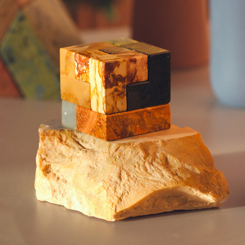 Natural stone Soma cube puzzle enhancing a minimalist desktop with its slow design.