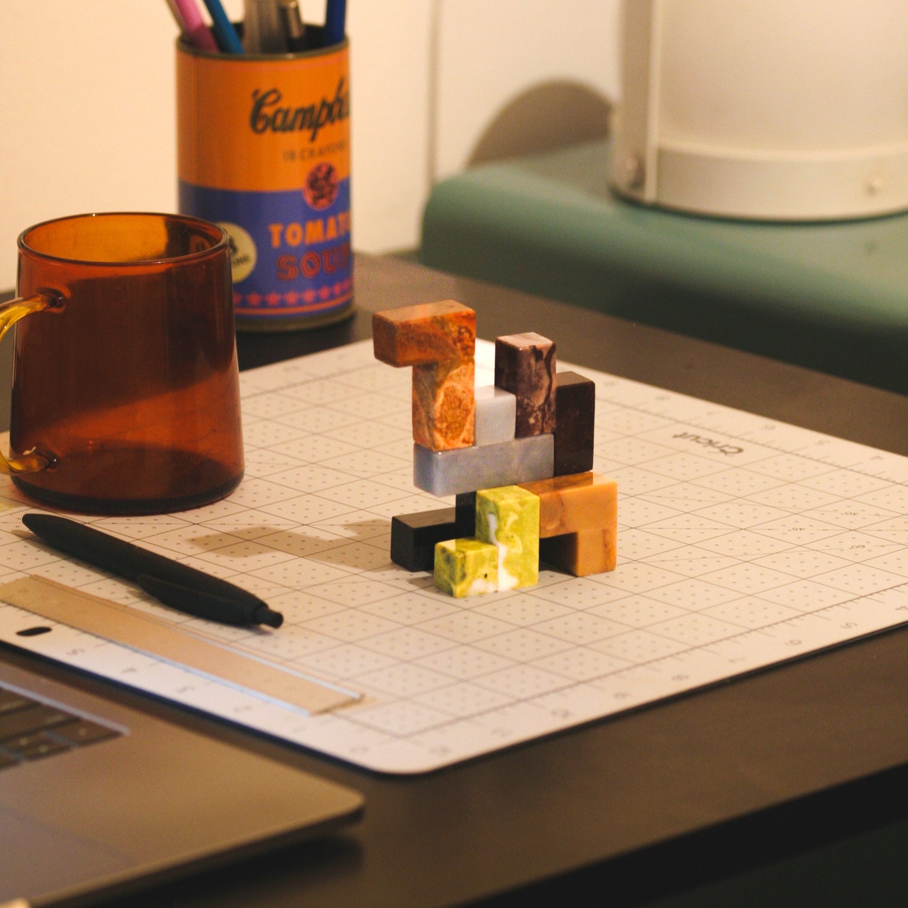 A partially solved gemstone Soma puzzle displayed on a textured surface, inviting interaction and mindfulness through its thoughtful slow design.