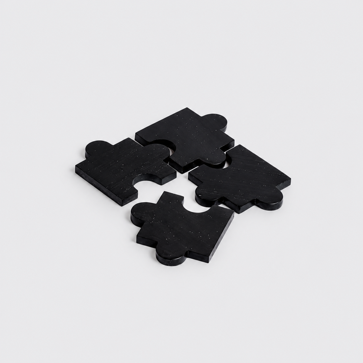 Set of 4 black onyx gemstone puzzle coasters highlighting their sleek matte finish on a white background.