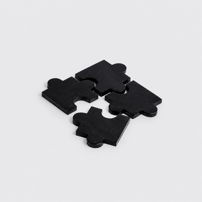 Set of 4 black onyx gemstone puzzle coasters highlighting their sleek matte finish on a white background.