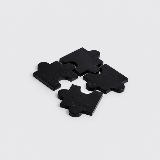 Set of 4 black onyx gemstone puzzle coasters highlighting their sleek matte finish on a white background.