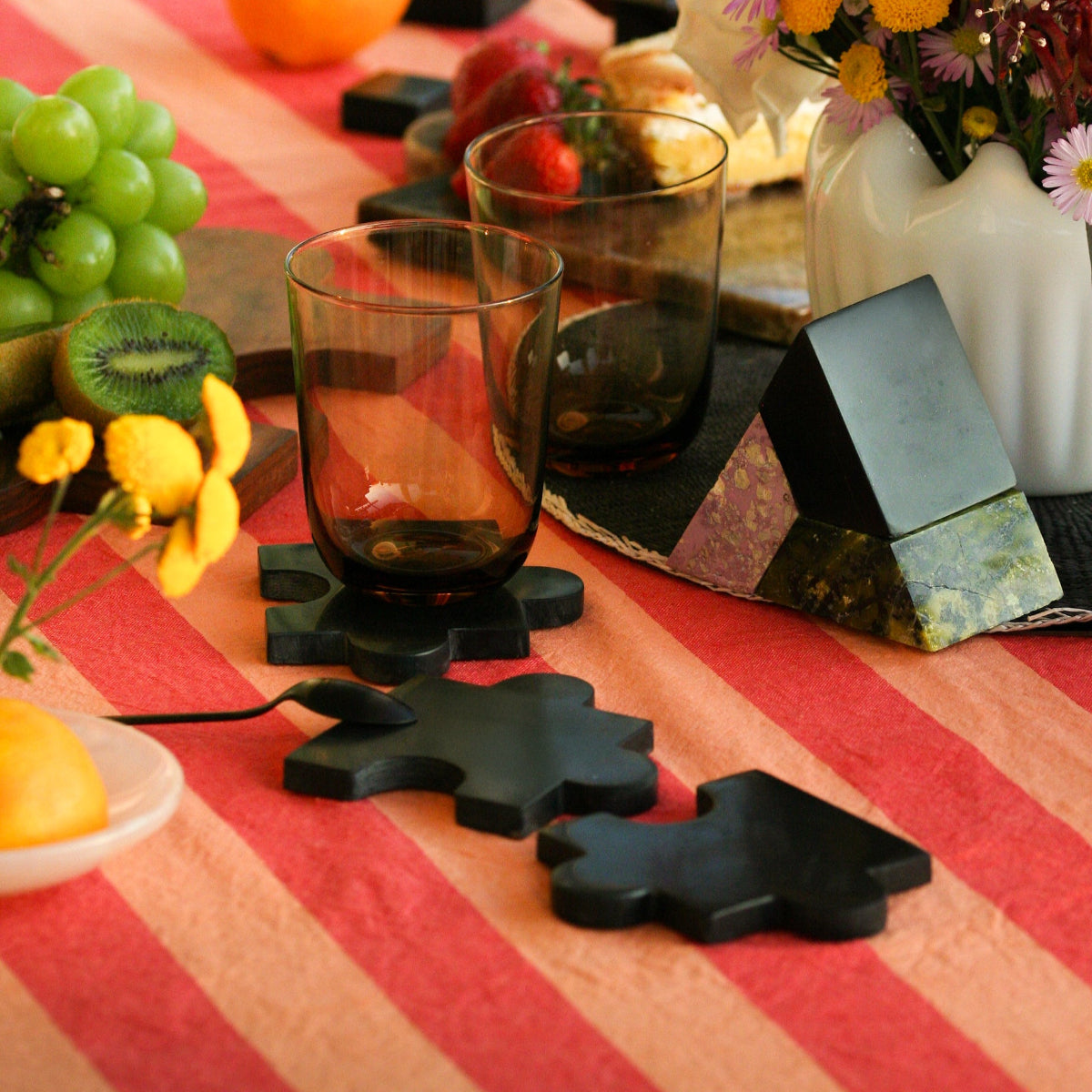 Handcrafted gemstone puzzle coasters serving as an elegant and heavy mineral centerpiece for a curated table setting.