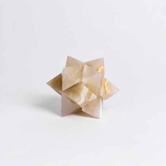 Geometric stone sculpture on a light gray background