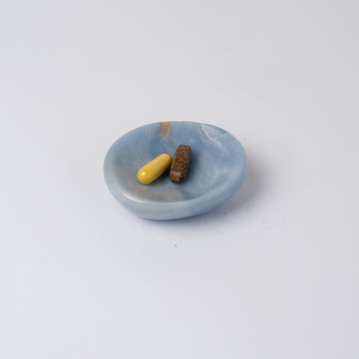 Solid blue angelite stone catch-all highlighting its handcrafted organic shape on a white background.