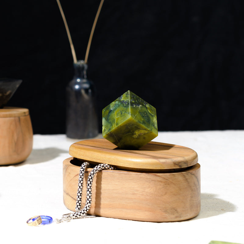 Handcrafted serpentine stone oval jewel box acting as an elegant storage accessory in a quiet luxury space.