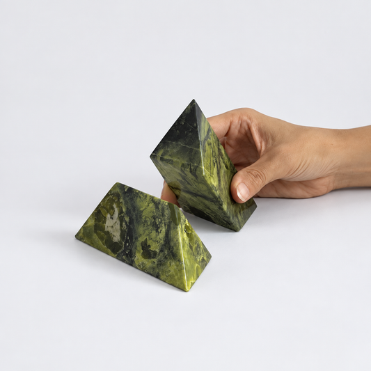 Serpentine green pyramid puzzle sculpture showcasing deep natural veins on a white background.