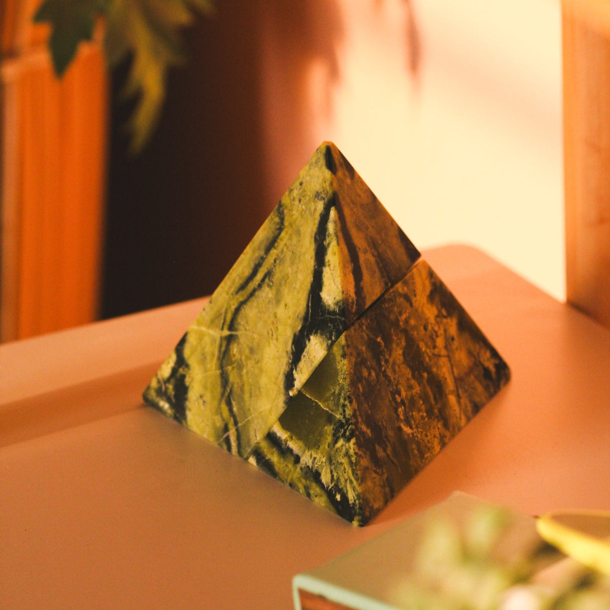 Decorative serpentine green pyramid bringing a sense of calm and weight to a quiet luxury space.