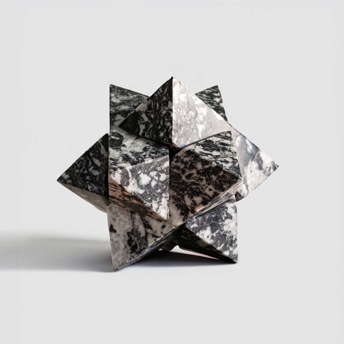 Star-shaped puzzle carved from zebra jasper against a clean background, highlighting the symmetry and strict proportionality of its six interlocking pieces.