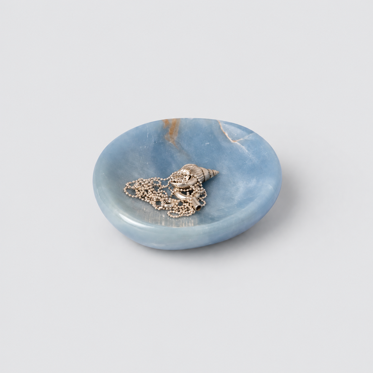 Organic 4-inch blue angelite gemstone catch-all dish displaying soft natural hues on a white background.