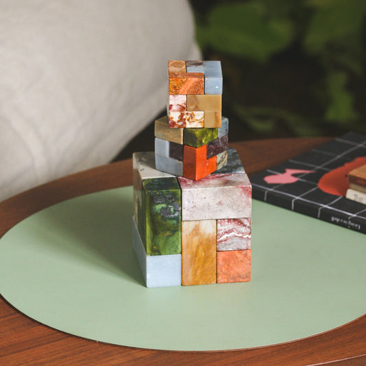 Large scale XL Soma Cube made of 7 colorful Andean gemstones on a designer coffee table.