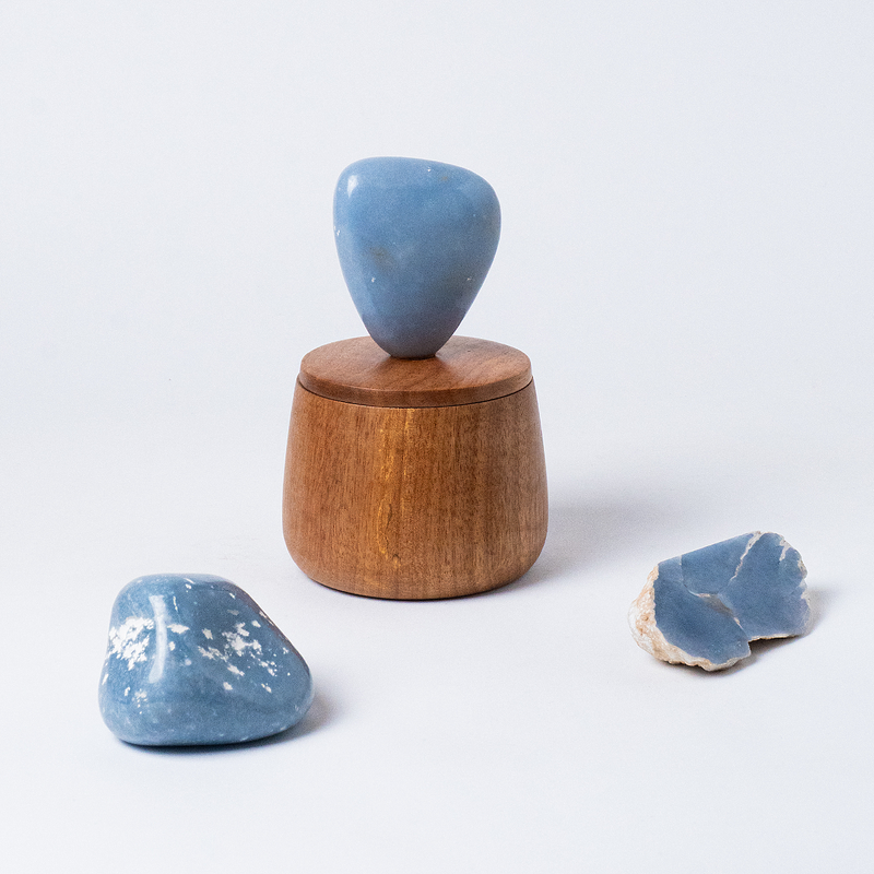 Solid blue angelite gemstone cloud round jewel box emphasizing its heavy mineral weight and calming hues on a white background.