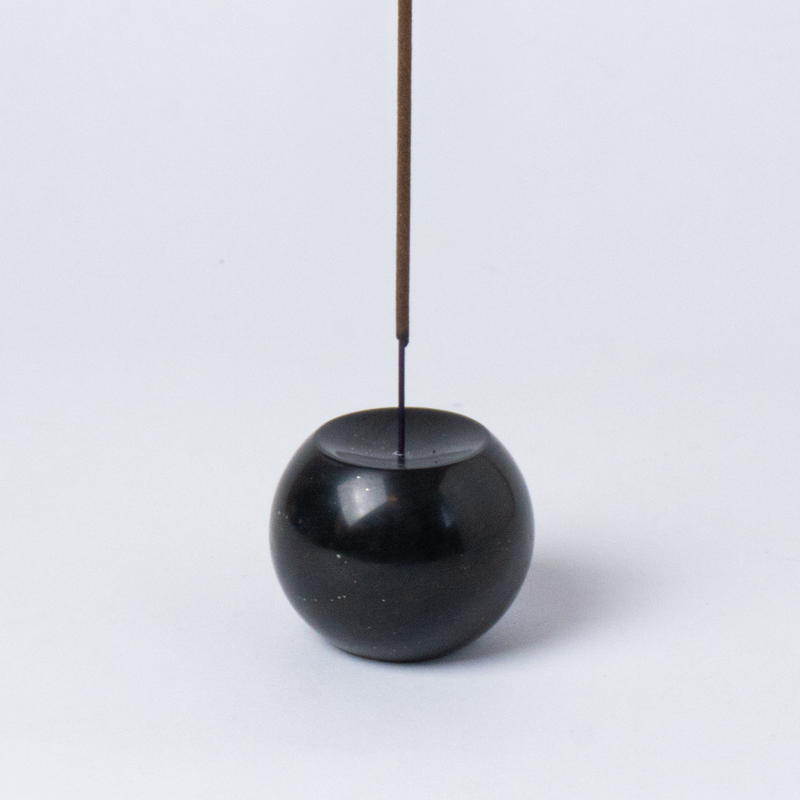 Close-up view of the black onyx gemstone sphere incense holder highlighting its smooth, dark finish on a white background.